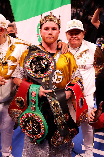 Canelo Alvarez poses with the belts after his championship bout for Alvarez's WBC, WBO and WBA super middleweight titles and Plant's IBF super...