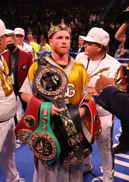 Canelo Alvarez poses with the belts after his championship bout for Alvarez's WBC, WBO and WBA super middleweight titles and Plant's IBF super...