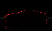 Car covered with a red cloth isolated on a black background