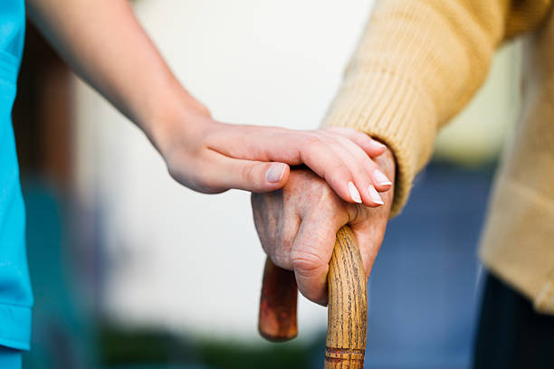 Care provider holding senior patient's hand