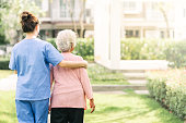 caregiver walking with elderly woman outdoor