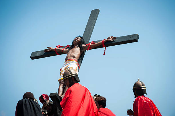 Catholic devotee is hoisted up onto a cross by participants during a reenactment of the crucifixion of Christ on Good Friday on April 3, 2015 in San...