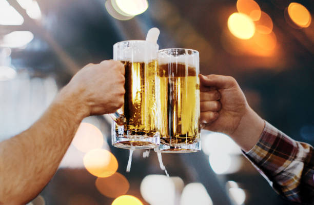 celebratory toast with pints of beer. - pint glass cheers stock pictures, royalty-free photos & images