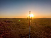 5G Cell Tower At Sunset: Cellular communications tower for mobile phone and video data transmission