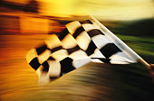 Checkered flag waving at an car race.