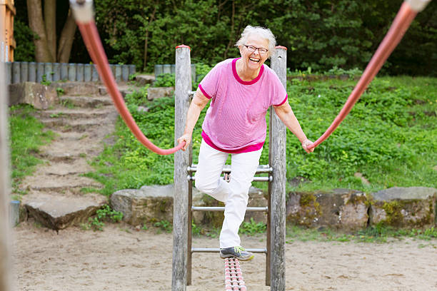 cheerful senior woman on playground balancing