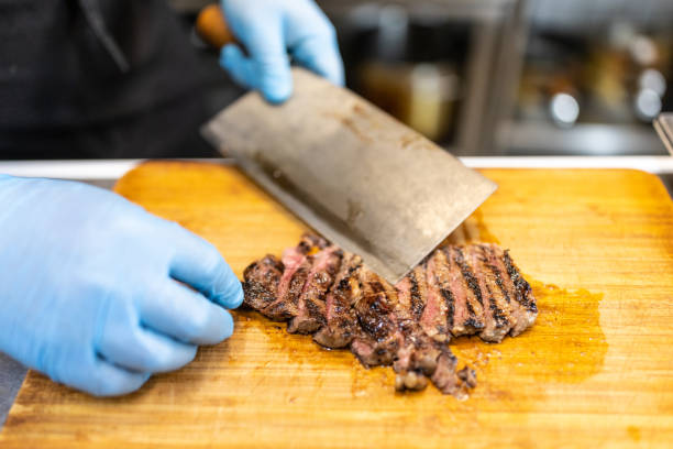 chef slicing roast beef using cleaver knife picture