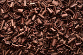 Chocolate pieces background. Top view of chocolate shavings