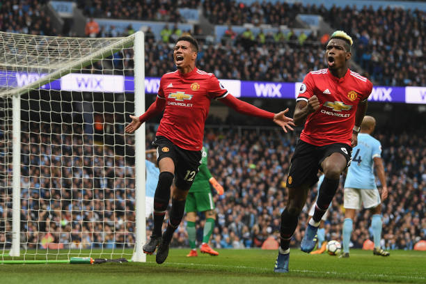 Chris Smalling of Manchester United celebrates scoring his side's third goal with Paul Pogba during the Premier League match between Manchester City...