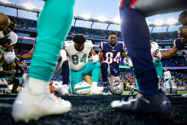 Christian Wilkins of the Miami Dolphins and Ben Watson of the New England Patriots pray following a game at Gillette Stadium on December 29, 2019 in...