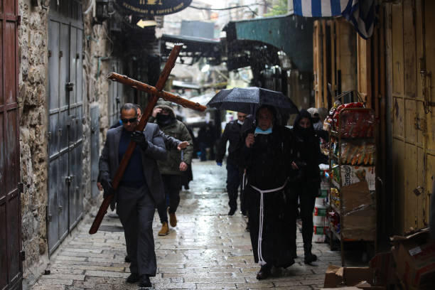 Christians walk along Via Dolorosa on quiet Good Friday due to the restrictions on public gatherings amid the coronavirus in Jerusalem on April 10,...