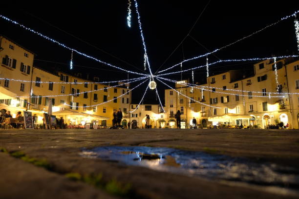 Christmas decorations and lights suspended at the top, in Piazza dell’anfiteatro in Lucca