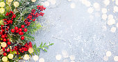 Christmas or winter background with a border of evergreen branches and red berries