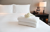 Clean white bath towels on the neatly clean bedroom - coziness and clean concept