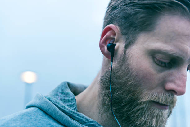 close-up de fone de ouvido usado por um homem com barba - streaming de radio  - fotografias e filmes do acervo