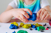 Close up of kids hands molding colorful child's play clay