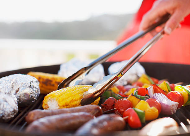 Close up of man grilling food on barbecue