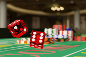 Close up shot of a pair of dice rolling down a craps table. Selective focus.Gambling concept. 3d illustration.