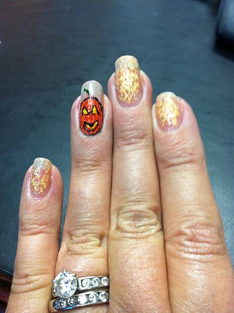 close-up of a hand with pumpkin design on finger nails - halloween nails stock pictures, royalty-free photos & images