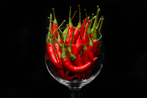 Close-up of red chili peppers in bowl against black background