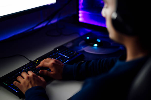 close-up on the hands of the gamer playing in the video game on a keyboard - streaming live - fotografias e filmes do acervo