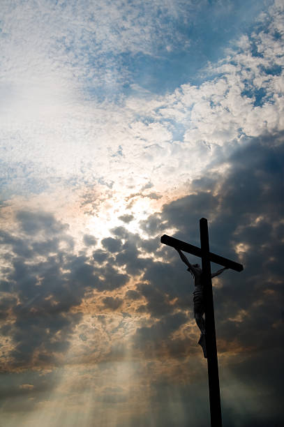 clouds, rays of sun, and crucifix - good friday stockfoto's en -beelden