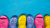 Colored bright slippers for women and children flip flops on a blue background. Place for text