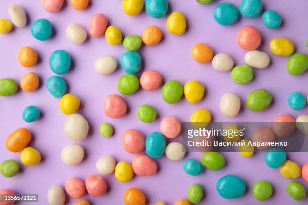 colorful chocolate candy pills purple background