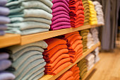 Colorful display of sweaters on shelf in store