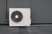 Condensing unit of air conditioning systems. Condensing unit installed on the gray wall.
