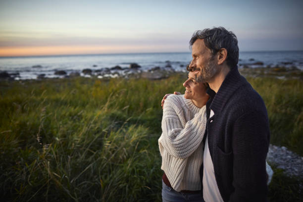 confident couple looking at view at the sea - happy couple stock pictures, royalty-free photos & images