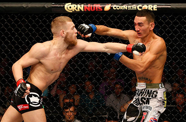 Conor McGregor punches Max Holloway in their UFC featherweight bout at TD Garden on August 17, 2013 in Boston, Massachusetts.