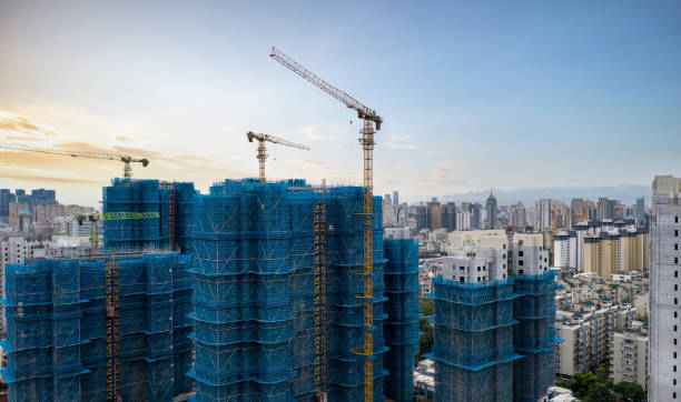 construction site of high-rise residential area using crane - obras - fotografias e filmes do acervo
