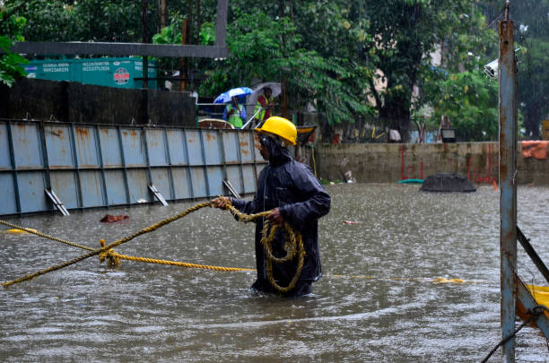 Construction worker wades through a flooded street due to heavy rainfall in Mumbai, India, 05 July, 2022.