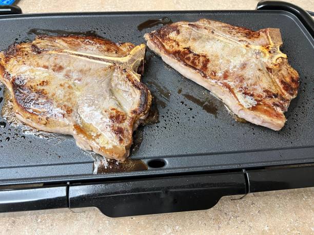 cooking steaks indoors on an electric griddle picture