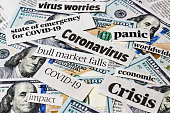 Coronavirus, covid-19 news headlines on United States of America 100 dollar bills. Concept of financial impact, stock market decline and crash due to worldwide pandemic