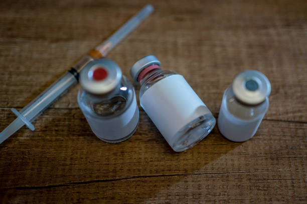 Coronavirus or COVID-19, 2019 - nCoV vaccine in a bottle with syringe and protective gloves and face mak on the table prepared for vaccinating.