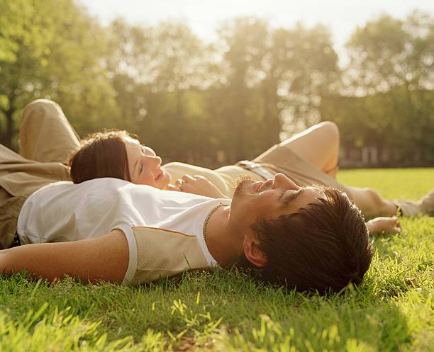 couple lying in park - couple self care stock pictures, royalty-free photos & images