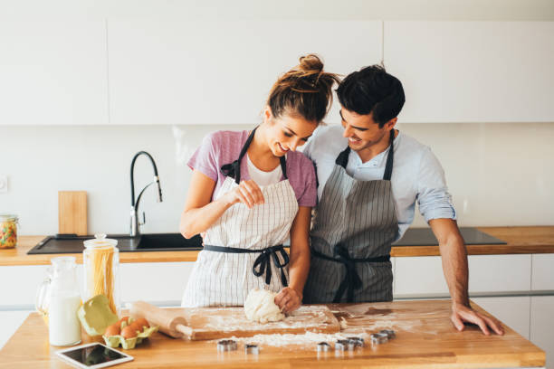 couple making cookies - couple baking stock pictures, royalty-free photos & images