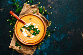 Creamy pumpkin soup in a wooden bowl