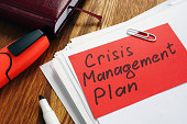 Crisis Management Plan on an office desk and papers.