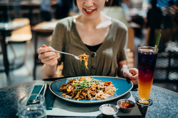 cropped shot of joyful young asian woman eating freshly served flat picture