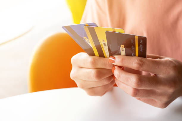 cropped shot view of female hands holding her credit cards. - conta de banco  - fotografias e filmes do acervo