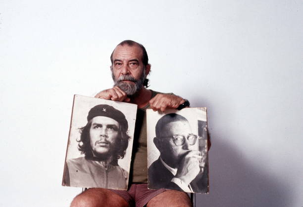 Cuban photographer, Alberto Korda, holding two of his works representing Che and Jean-Paul Sartre. Havana . 1988.