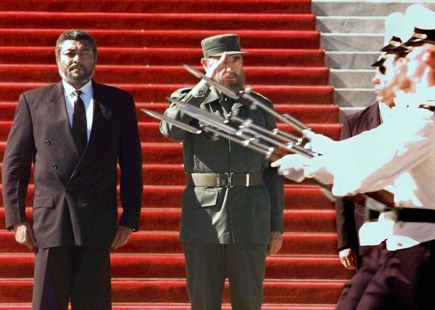 Cuban President Fidel Castro salutes honor troops 29 September during a welcome ceremony for Ghanan President Jerry Rawlings at the State Council in...