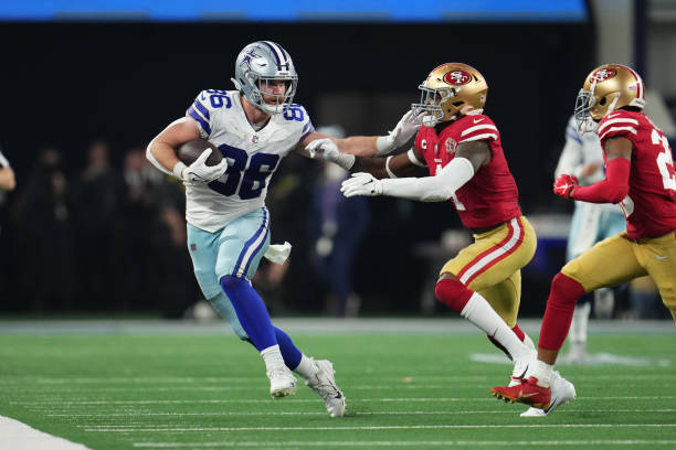 Dalton Schultz of the Dallas Cowboys stiff-arms Emmanuel Moseley of the San Francisco 49ers during an NFL wild-card playoff football game at AT&T...