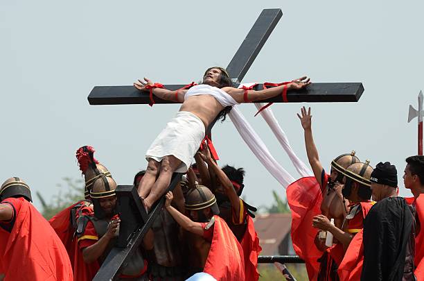 Dante Enage is hoisted up after being nailed to the cross for the 30th time this year on March 25, 2016 in San Fernando town in Pampanga province,...