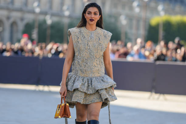Deepika Padukone wears a beige and gray tie and dye print pattern ruffled embossed pattern / sleeveless short dress from Louis Vuitton, a red LV...