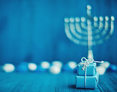 Defocused Hanukkah Background with Menorah, Gifts and Dreidel