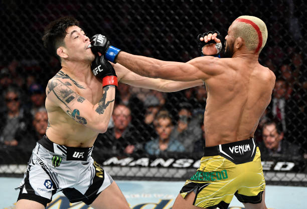 Deiveson Figueiredo of Brazil punches Brandon Moreno of Mexico in their UFC flyweight championship fight during the UFC 270 event at Honda Center on...